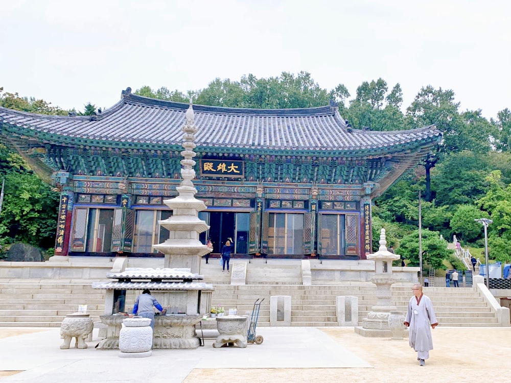 a person walking in front of a building with a fountain