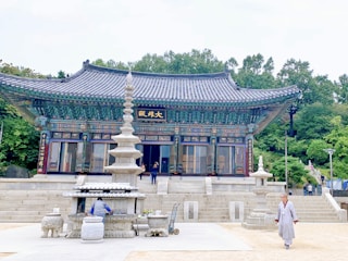 a person walking in front of a building with a fountain