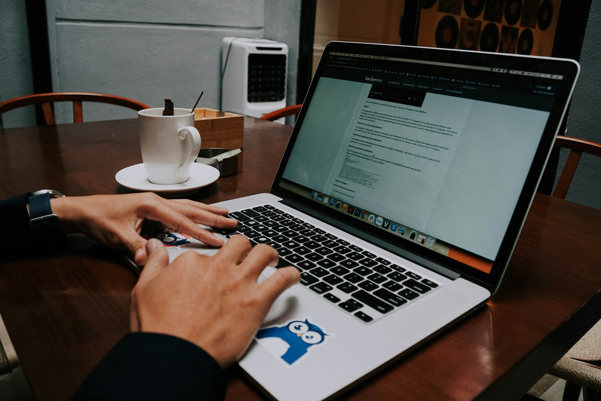 a person using a laptop on a wooden table