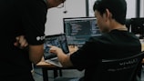 two men working on computers in an office