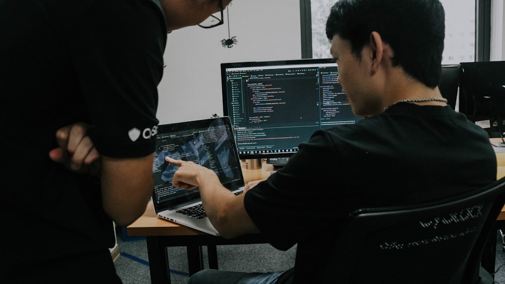 Dos hombres trabajando en computadoras en una oficina