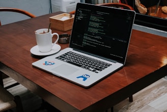 a laptop computer sitting on top of a wooden table