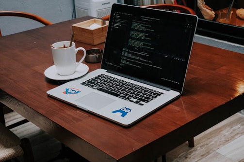 a laptop computer sitting on top of a wooden table