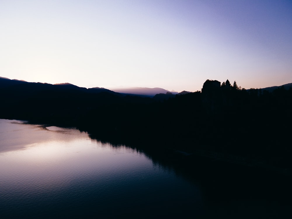 a body of water surrounded by mountains under a blue sky