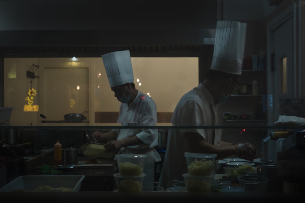 two chefs are preparing food in a kitchen