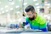 a man in a factory working on a piece of equipment