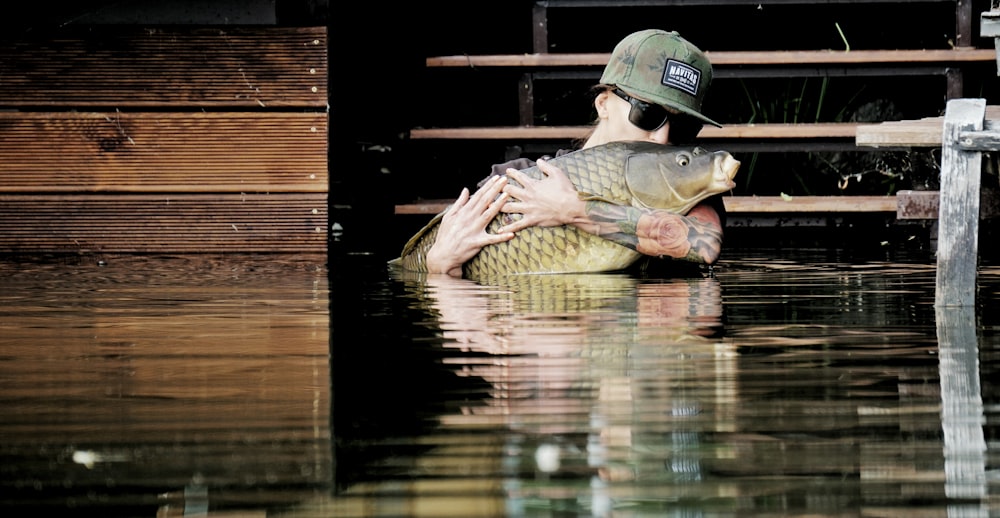 a man holding a fish in a body of water