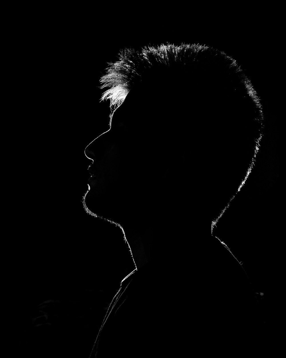 a black and white photo of a person in the dark