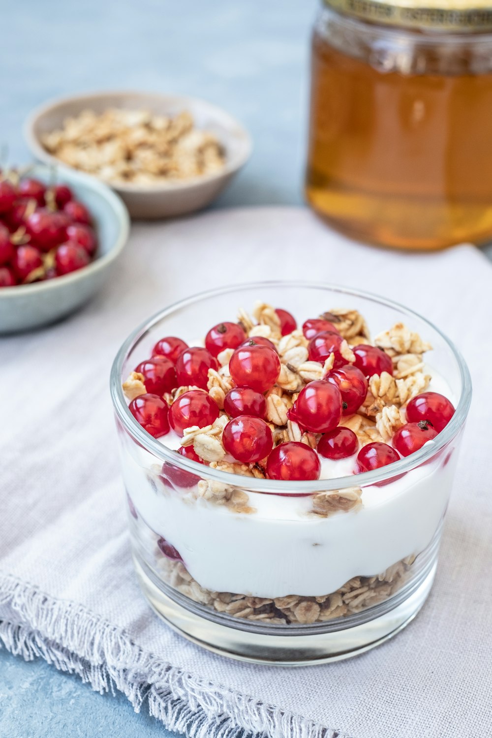 a bowl of yogurt, granola, and cherries on a table