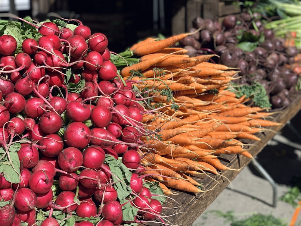 a bunch of radishes and carrots on a table