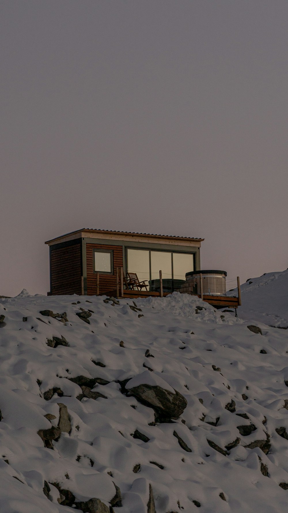 a small cabin sitting on top of a snow covered hill
