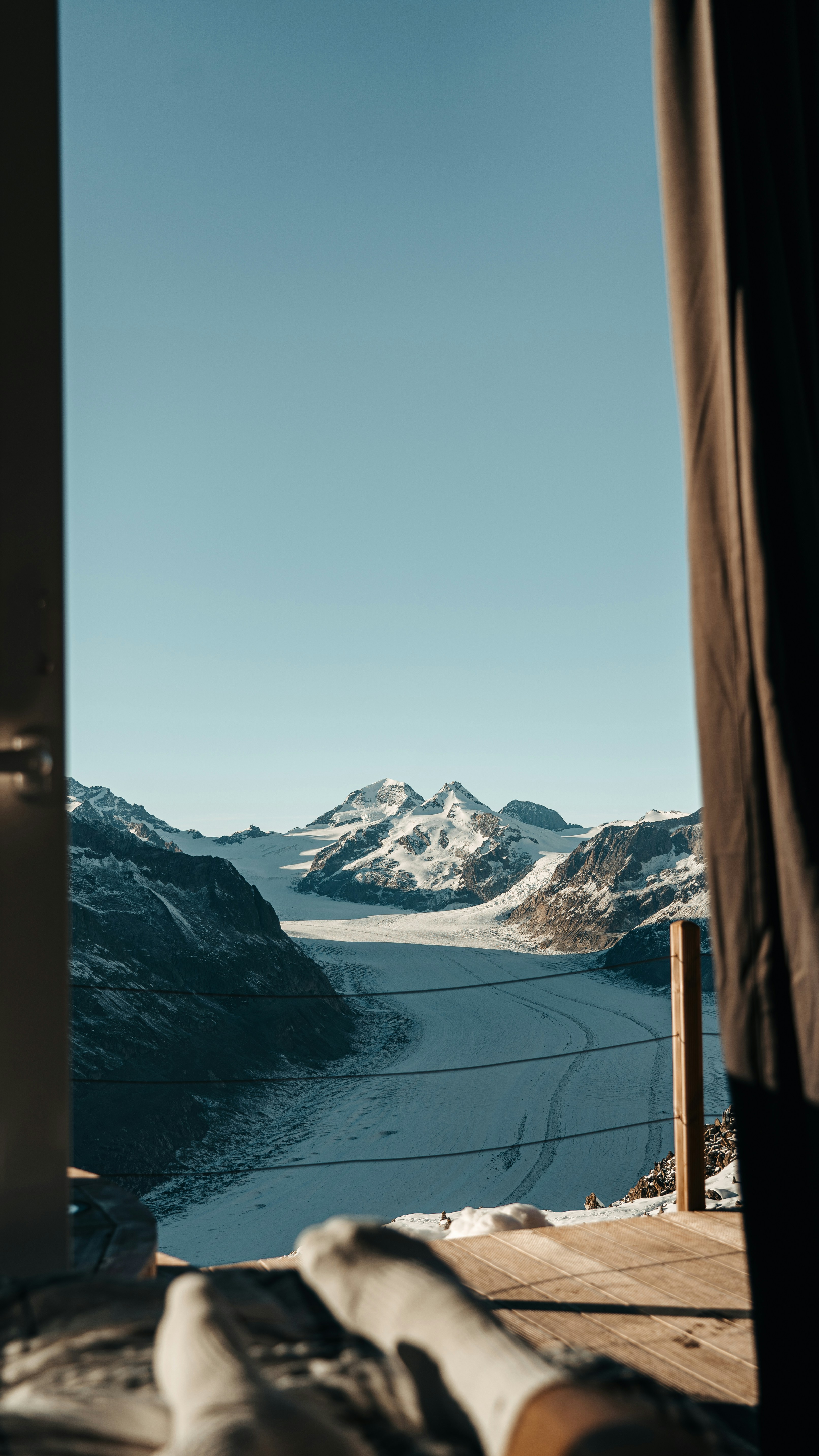 a view of a snowy mountain range through a window
