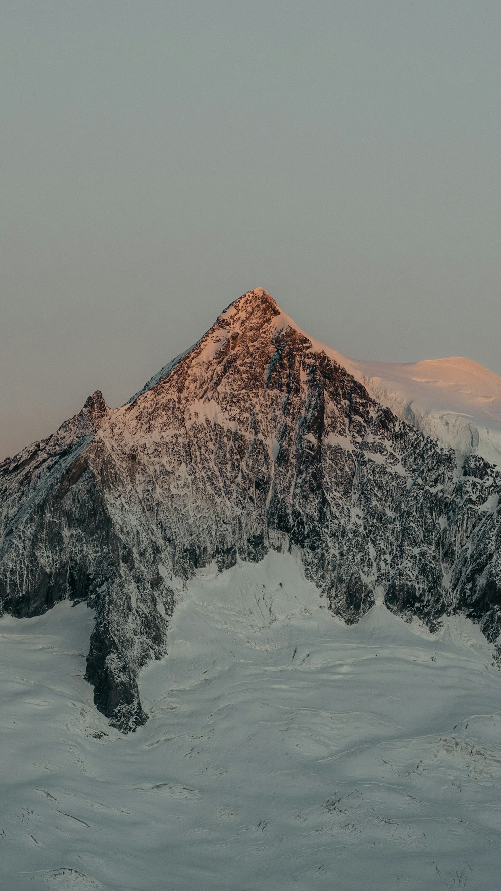 a mountain covered in snow with a sky background