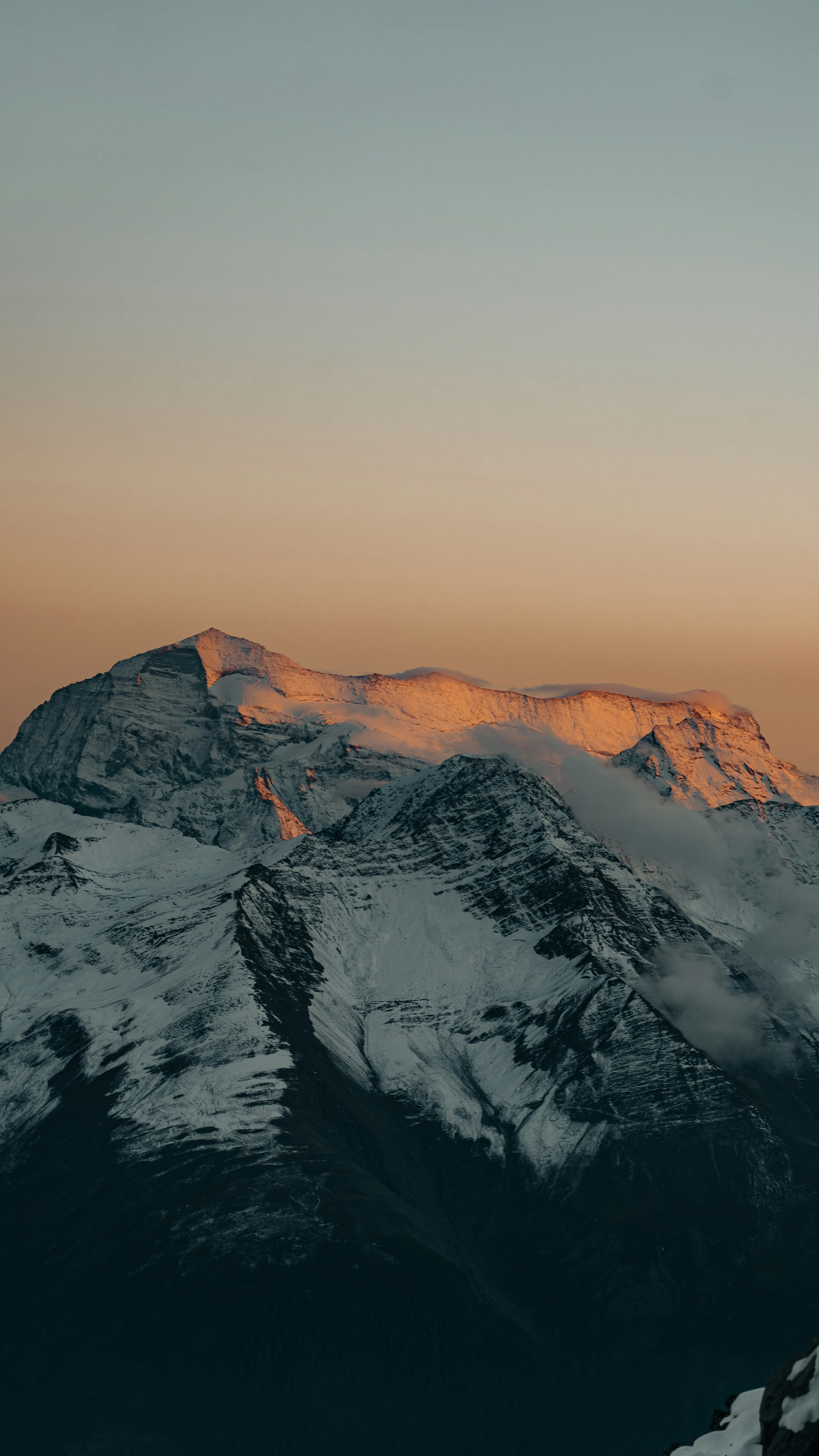 a snow covered mountain with a sunset in the background