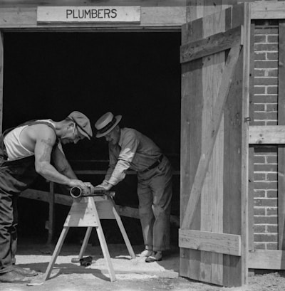 a couple of men working on a wooden structure