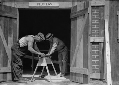 a couple of men working on a wooden structure