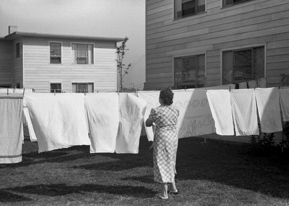 uma mulher em pé na frente de uma fila de roupas