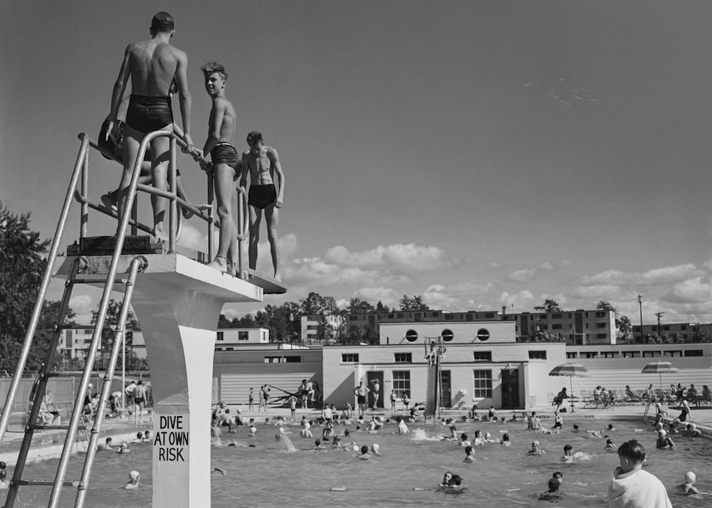 uma foto em preto e branco de pessoas em uma piscina