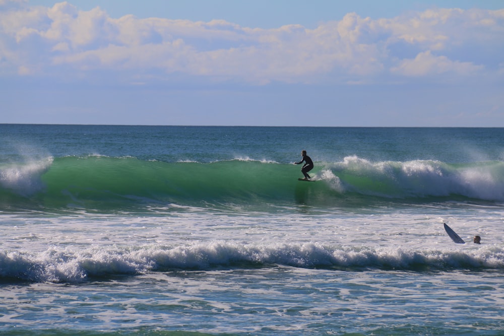 Un hombre montando una ola encima de una tabla de surf