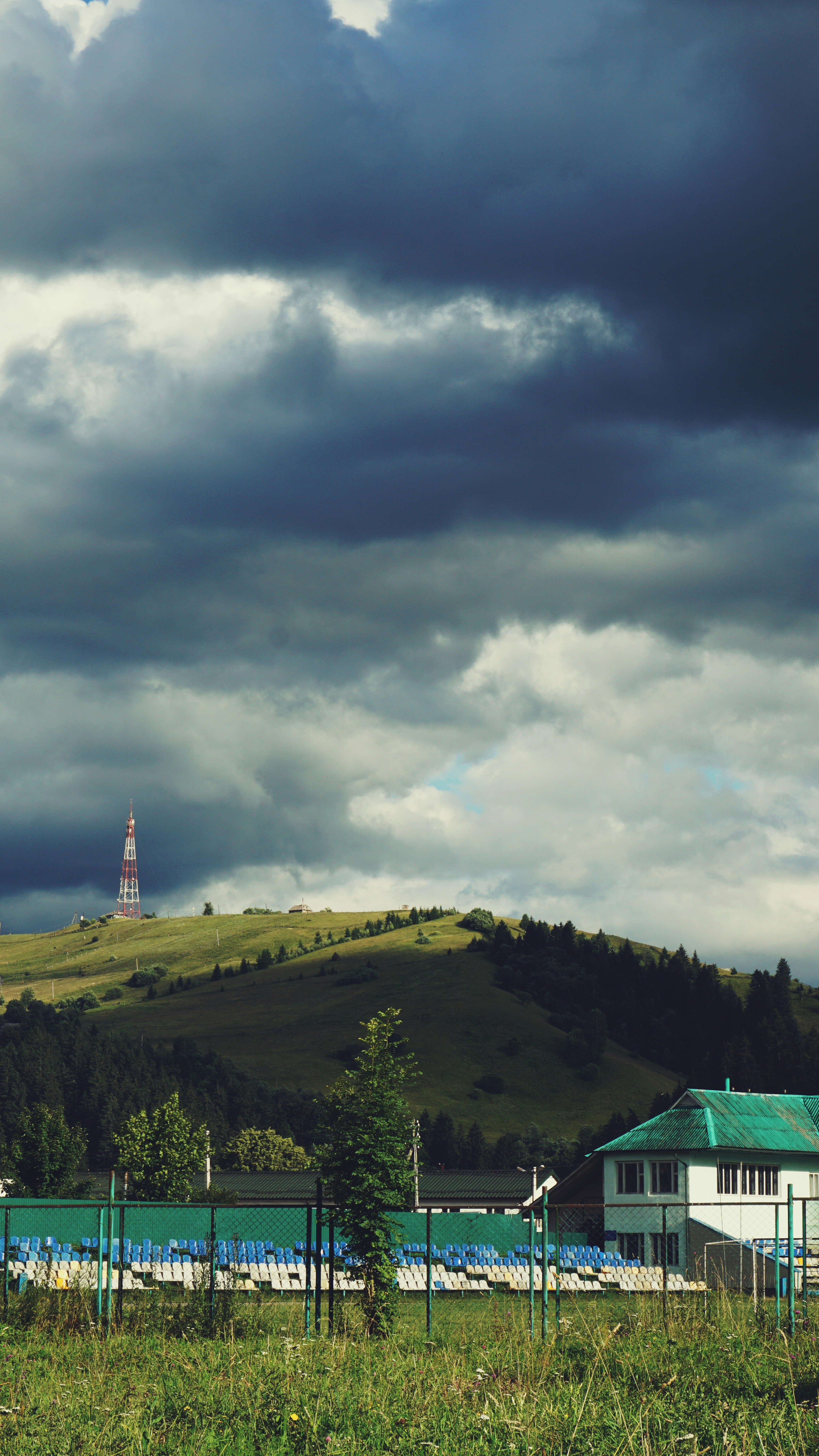 Un campo verde cubierto de hierba con un edificio blanco en una colina en el fondo