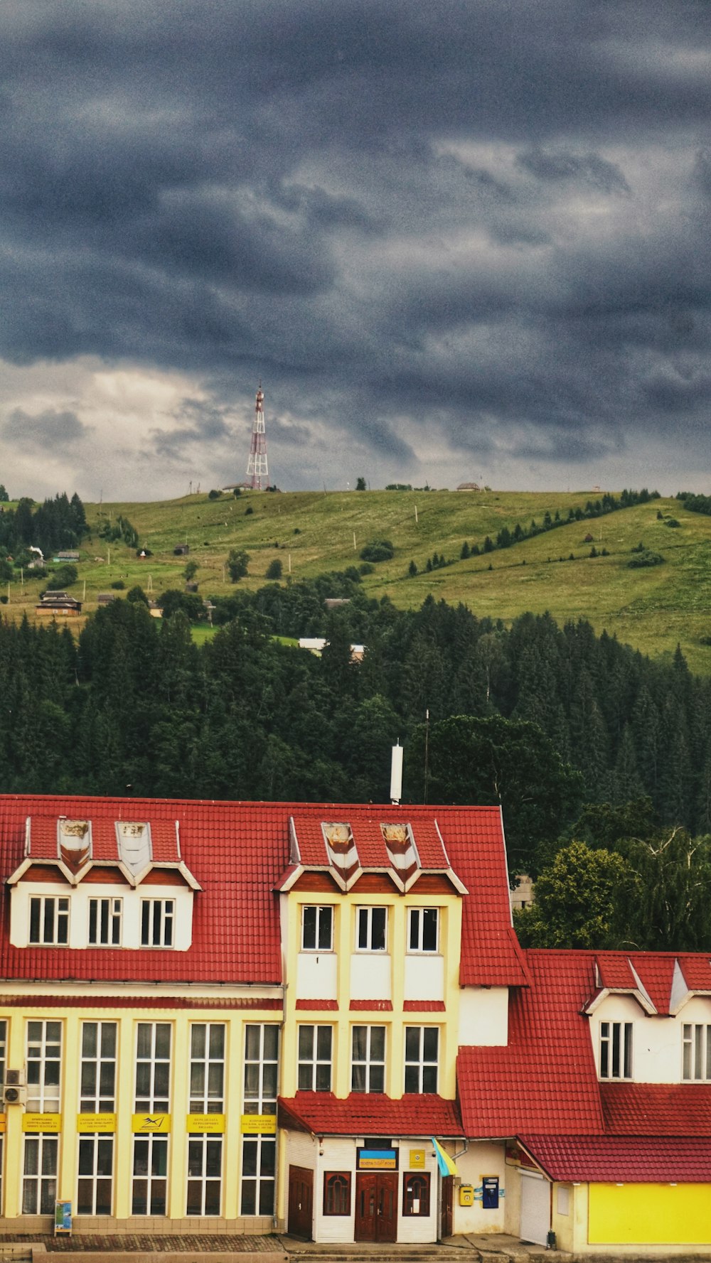 a large building with a red roof on a cloudy day