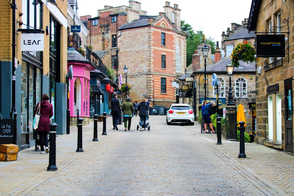 a group of people walking down a street next to tall buildings