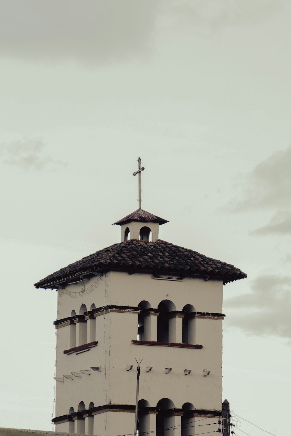 a tall white building with a cross on top of it
