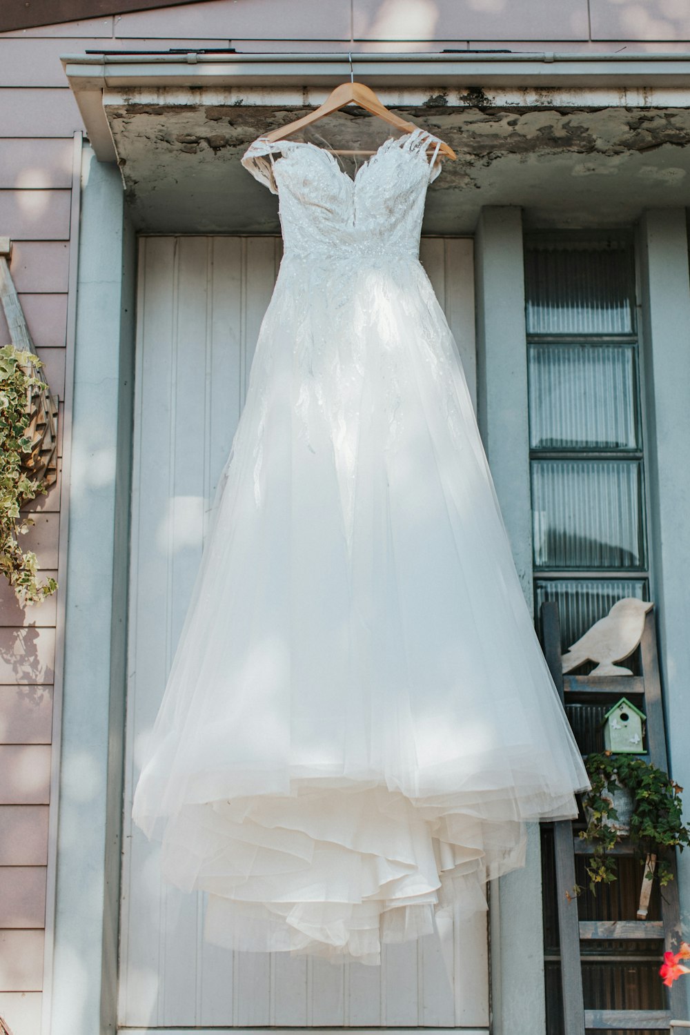 a wedding dress hanging on a rack in front of a door