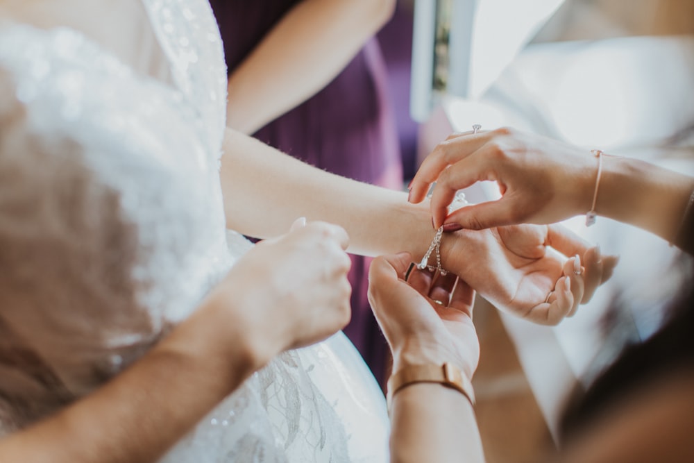 a bride putting a ring on her bridesmaid's finger