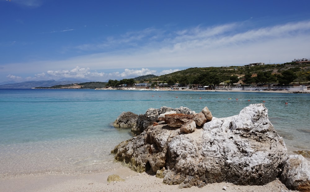 Ein Strand mit klarem blauem Wasser und Felsen