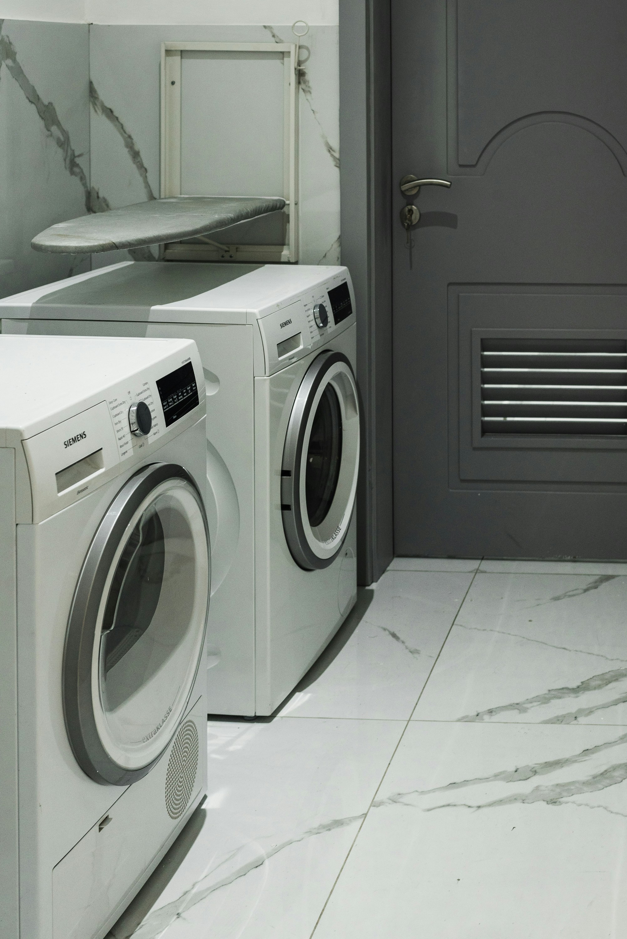 Interior pictures of a Stylish modern Washing Machine in a laundry area.