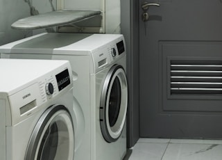 Interior pictures of a Stylish modern Washing Machine in a laundry area.