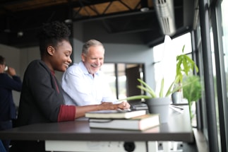 A friendly mortgage advisor discussing paperwork with a happy couple in a cozy office
