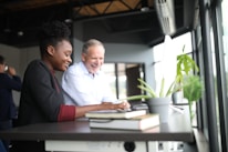 Friendly accountant explaining finances to a smiling client over a desk.