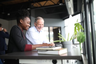 A friendly travel agent assisting a happy couple planning their trip at a bright office.