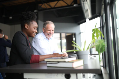 A smiling travel agent discussing itinerary details with a happy couple in a bright office.