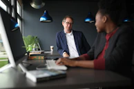Friendly interaction between lawyer and client in a comfortable office corner with blue décor.