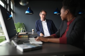 A woman therapist is talking to a man, both are seated in comfortables armchairs.