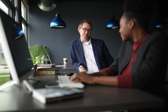 A woman therapist is talking to a man, both are seated in comfortables armchairs.
