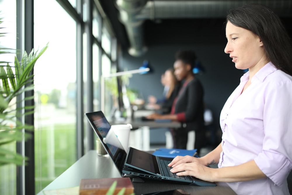 a woman sitting in front of a laptop computer