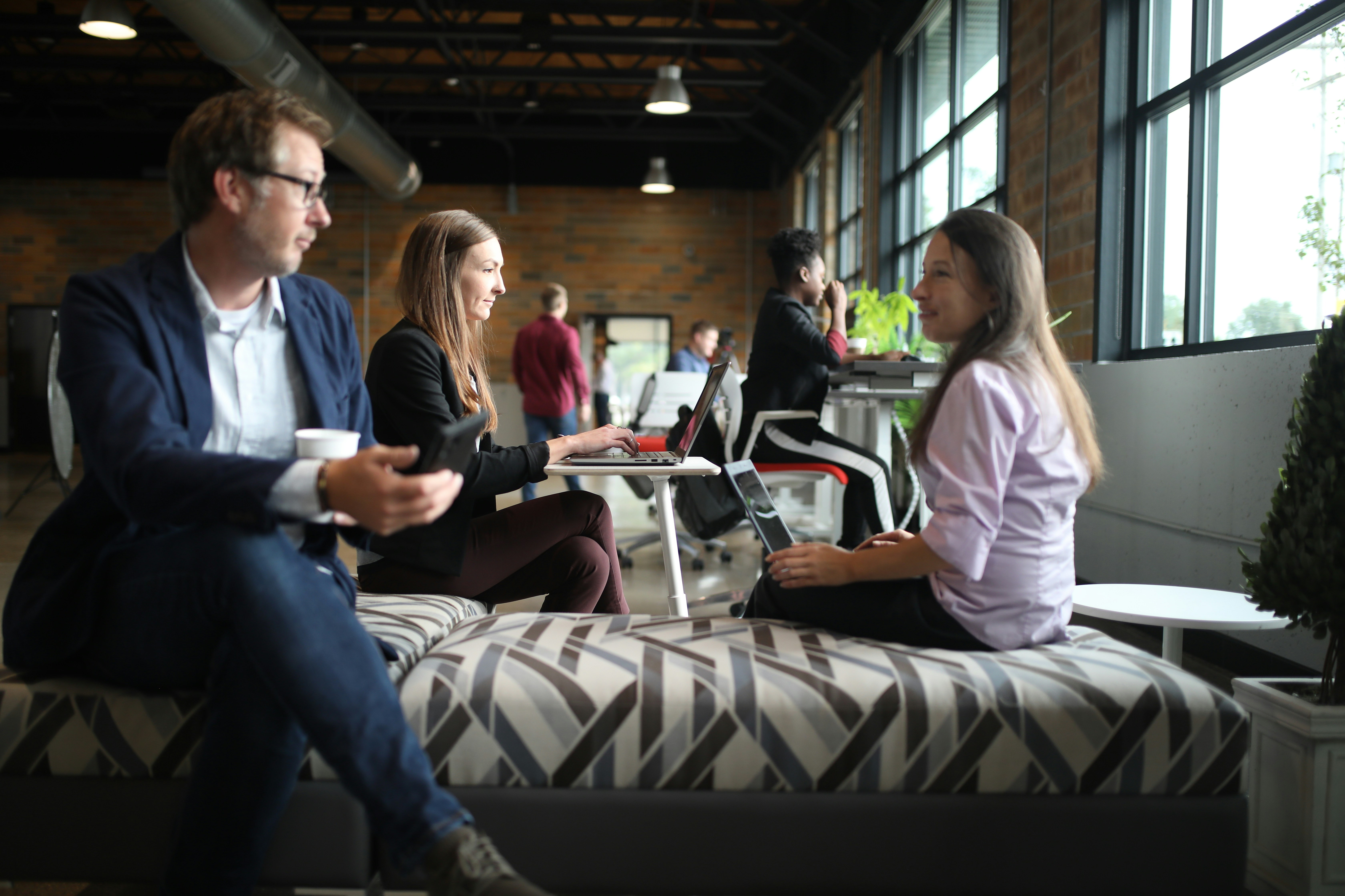 a group of people sitting around a bed in a room