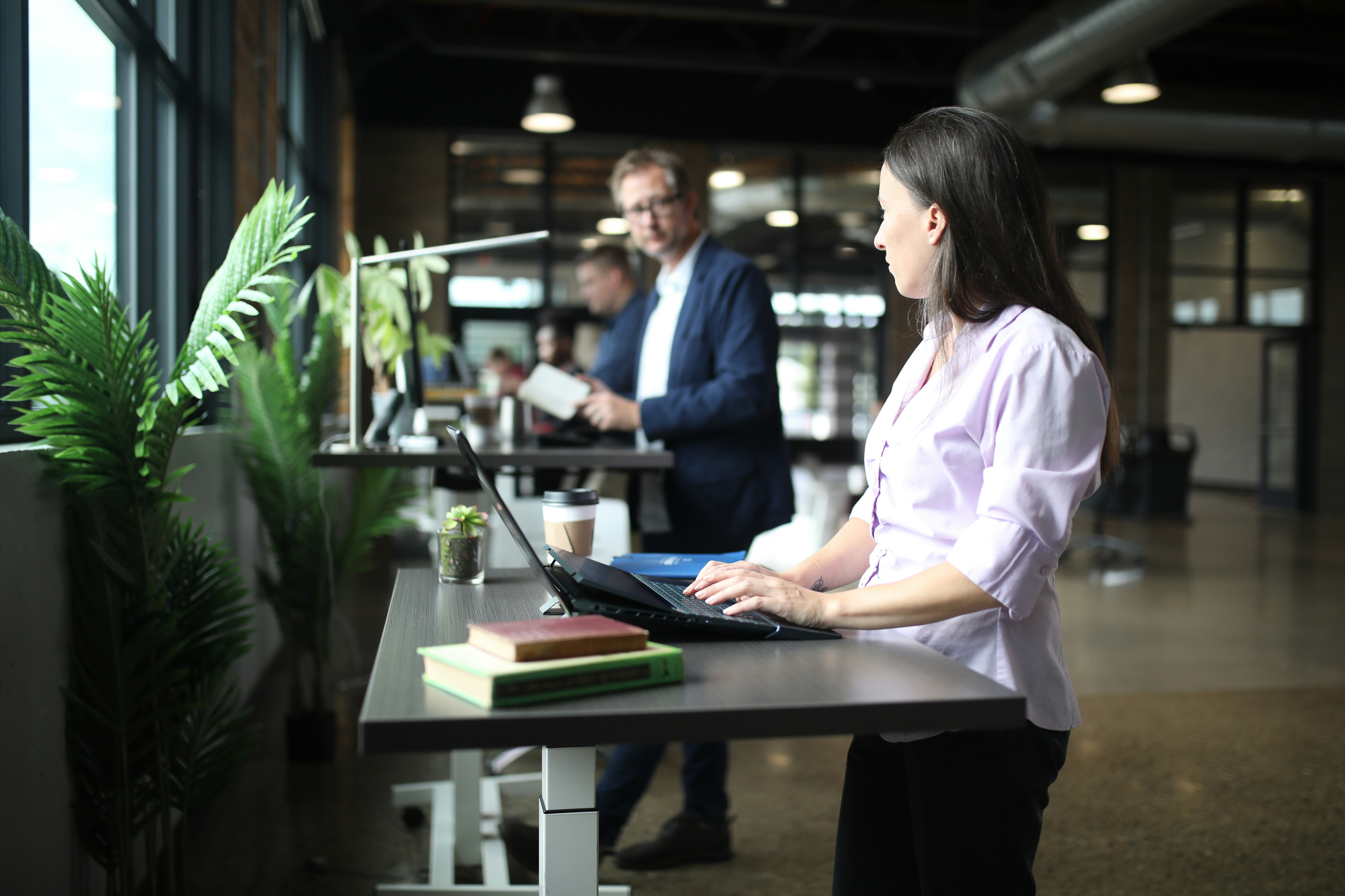 a woman sitting at a desk using a laptop computer, Shop now at https://thestandingdesk.com