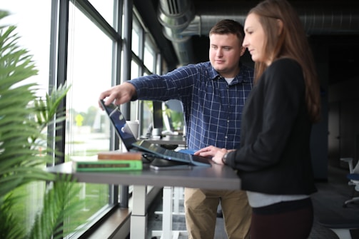 a man and a woman looking at a laptop