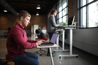 two people working at desks of different heights