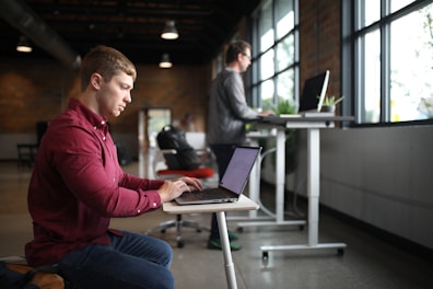 two people working at desks of different heights