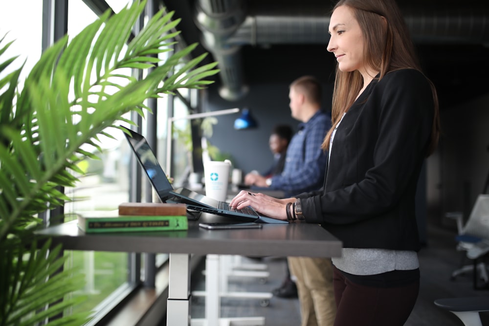 a woman sitting at a table using a laptop computer