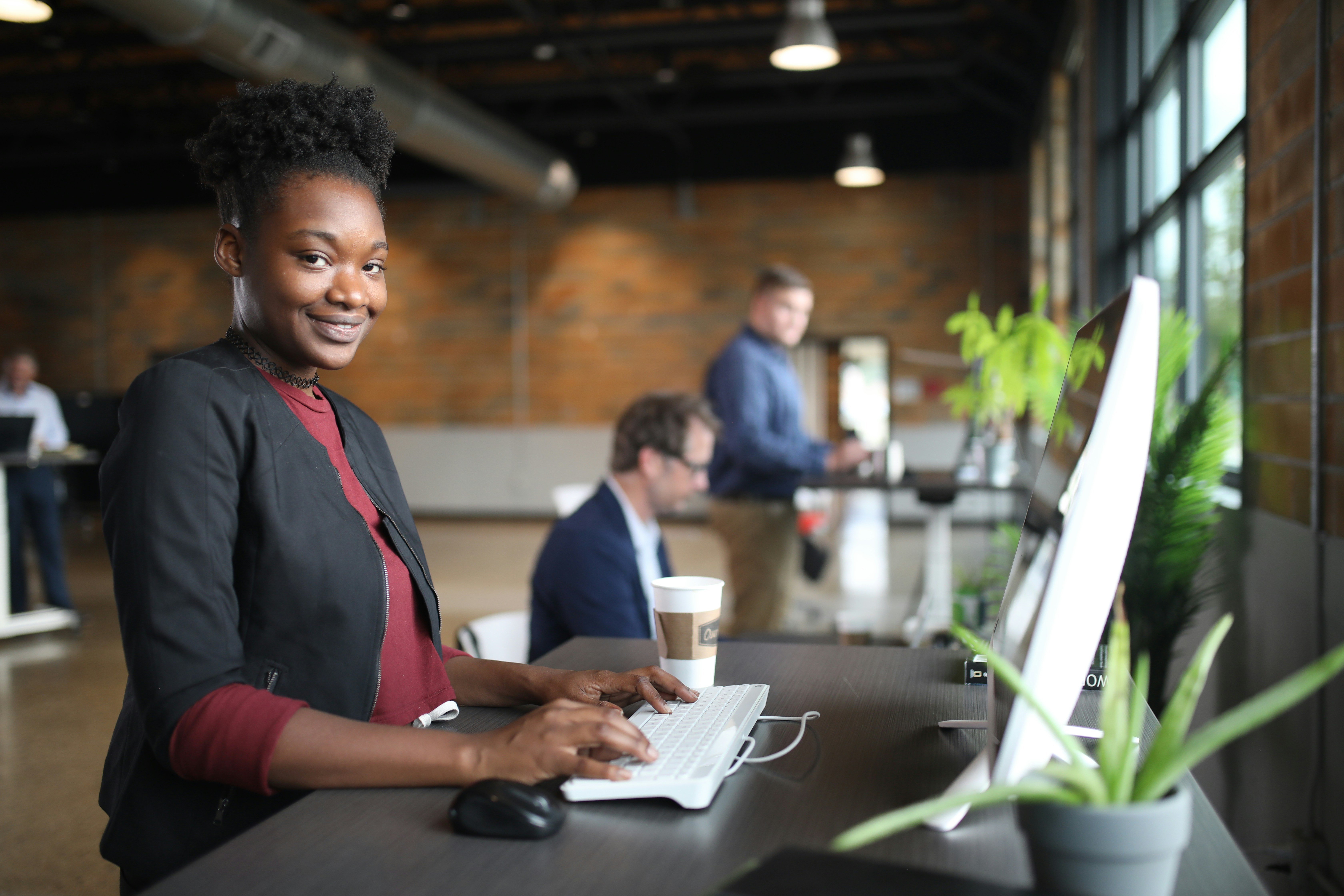 a woman sitting at a desk using a laptop computer, Shop now at https://thestandingdesk.com