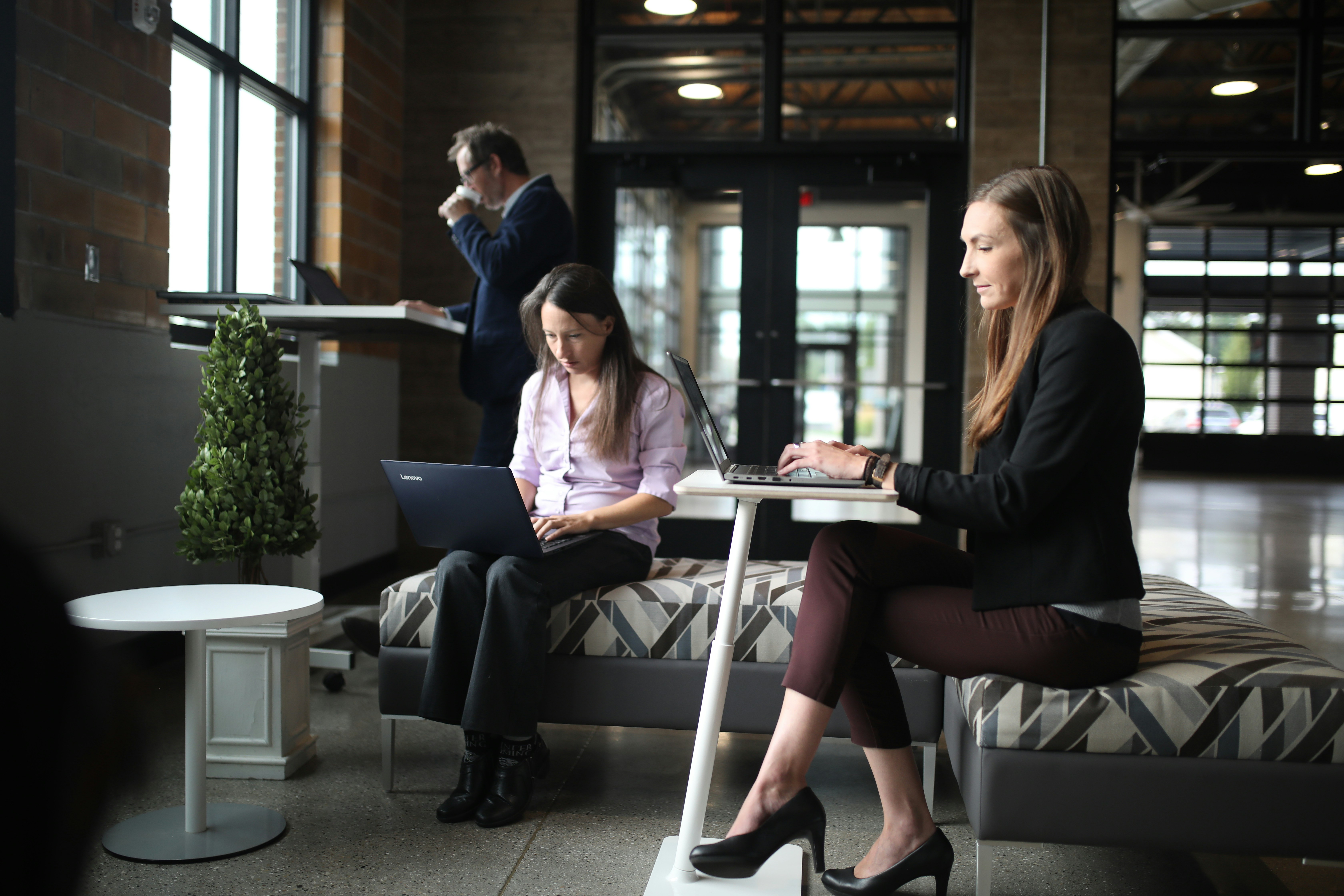 a woman sitting at a table using a laptop computer