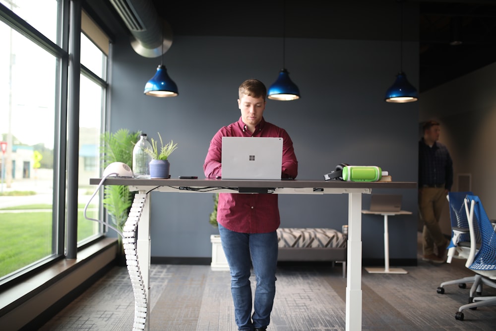 a man standing in front of a laptop computer