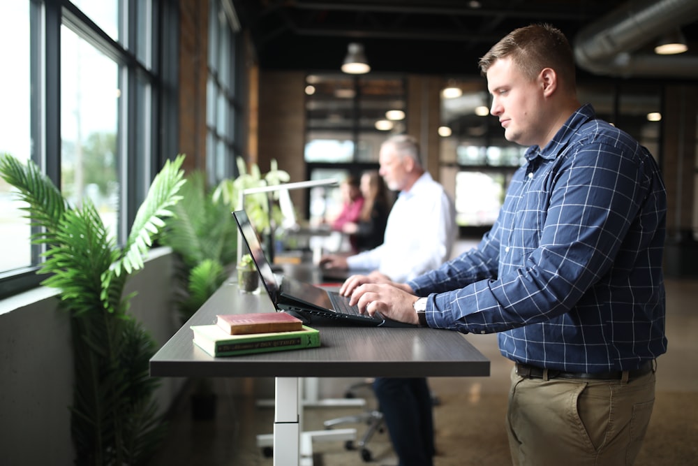 a man sitting at a table using a laptop computer